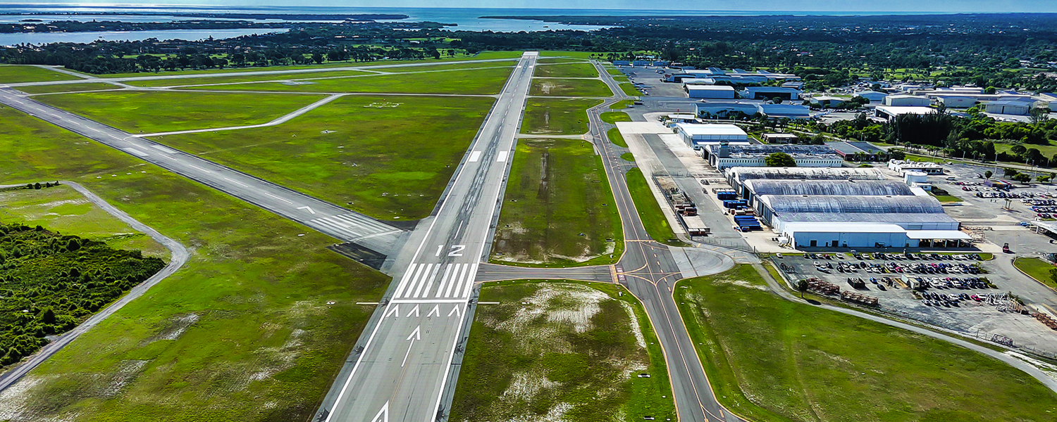 Drone image of Martin County Airport's reconstructed Taxiway A. The sun is shining and the blue sky is on the horizon.