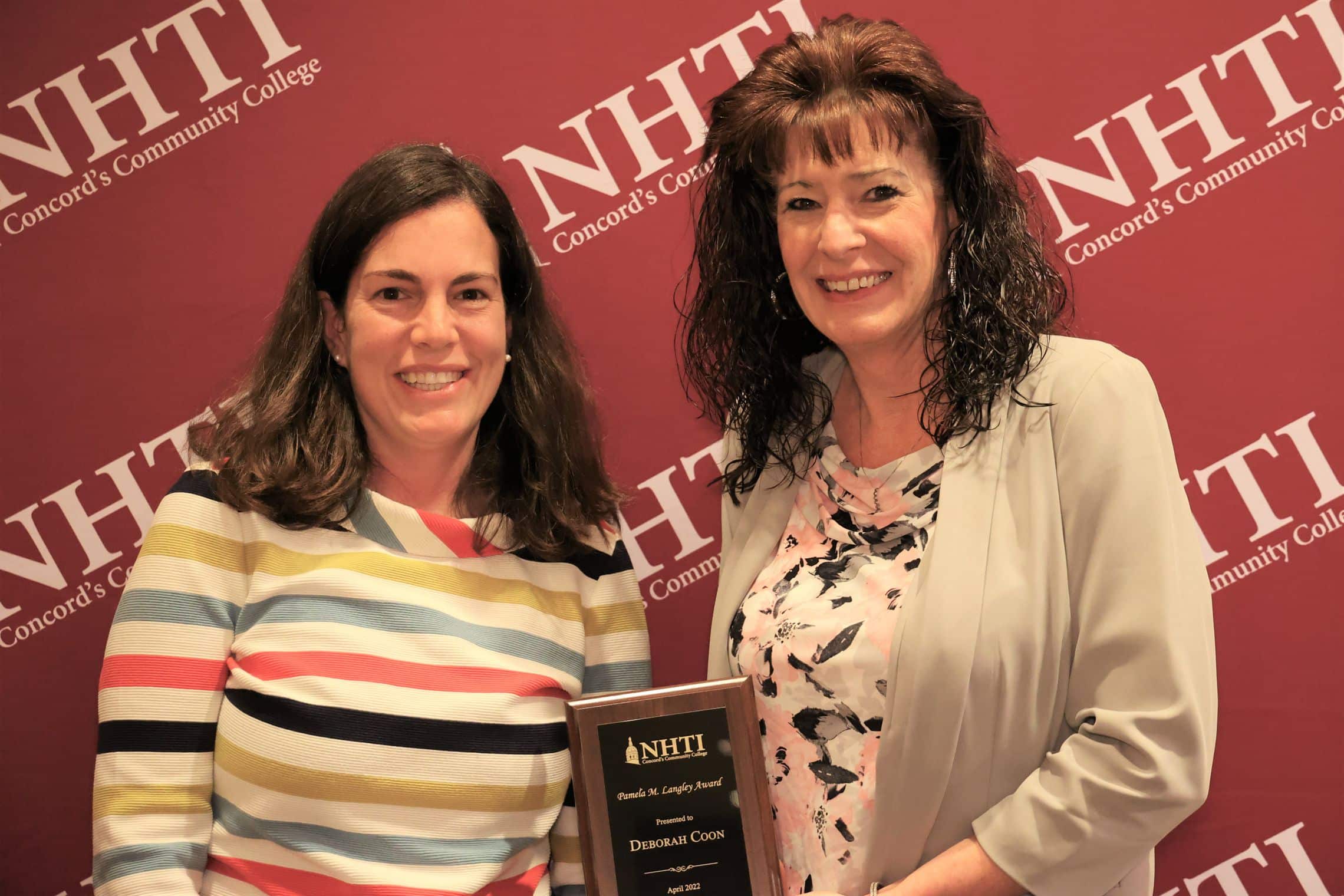 Recent graduate and Environmental Coordinator Deb Coon won the Dr. Pamela M. Langley Award for Exceptional Research in the Natural Sciences. She is pictured here with her award in front of an NHTI backdrop that is red.