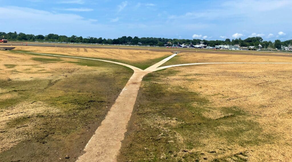 An image of a swale with no water being constructed at the airport. This was part of the safety improvement measures taken for this project.