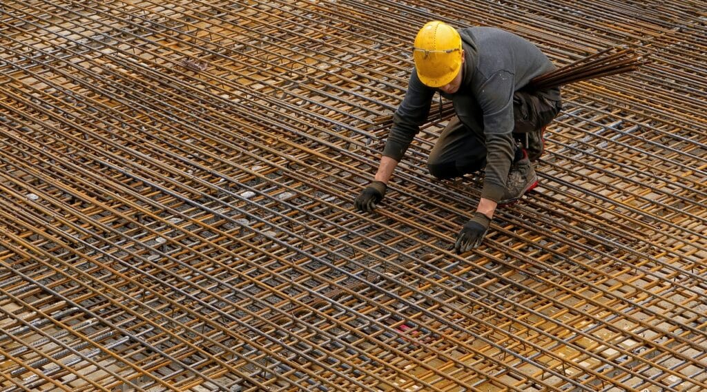 An image of a construction worker on black bar for bridge design. Alternate methods make bridges more resilient.