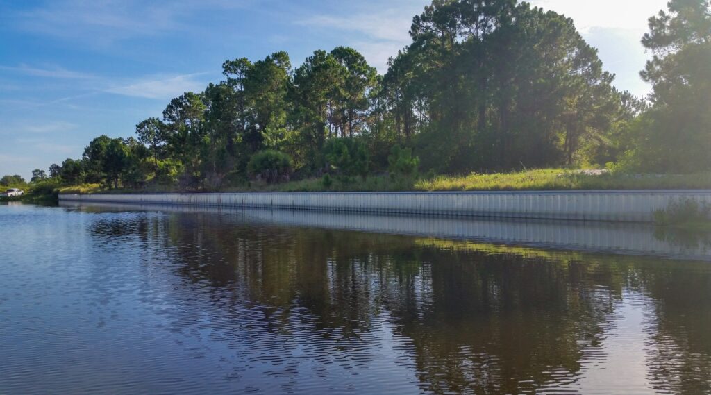 Sebastian Seawall photo - a picture of a seawall with trees in the background on a sunny day and quite sea waters. This is part of Payton's project variety she has had in her engineering career.