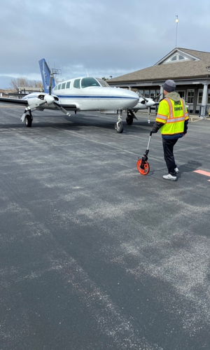 One of our construction inspectors on an airfield with a plane in the background.