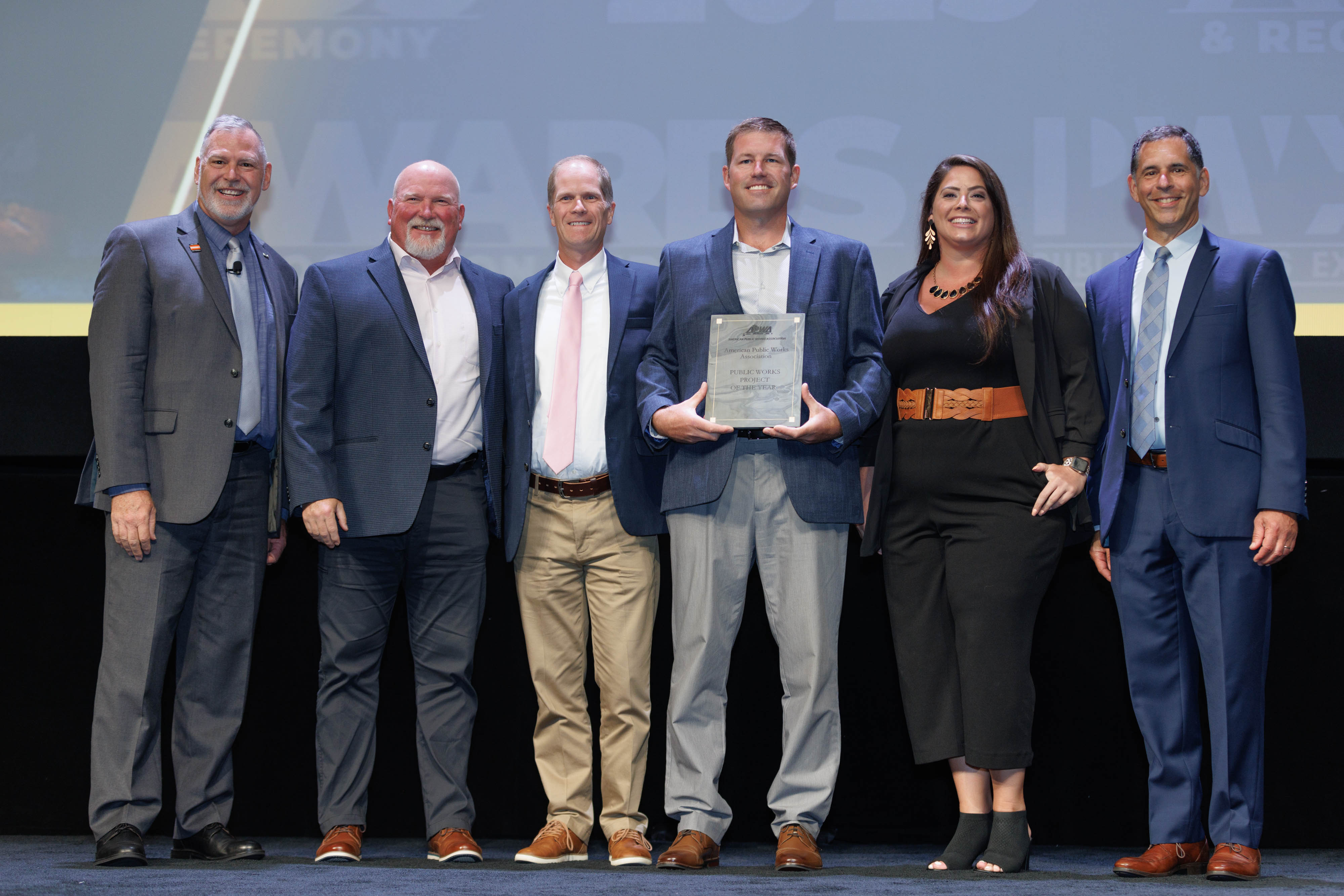 People standing on stage with award