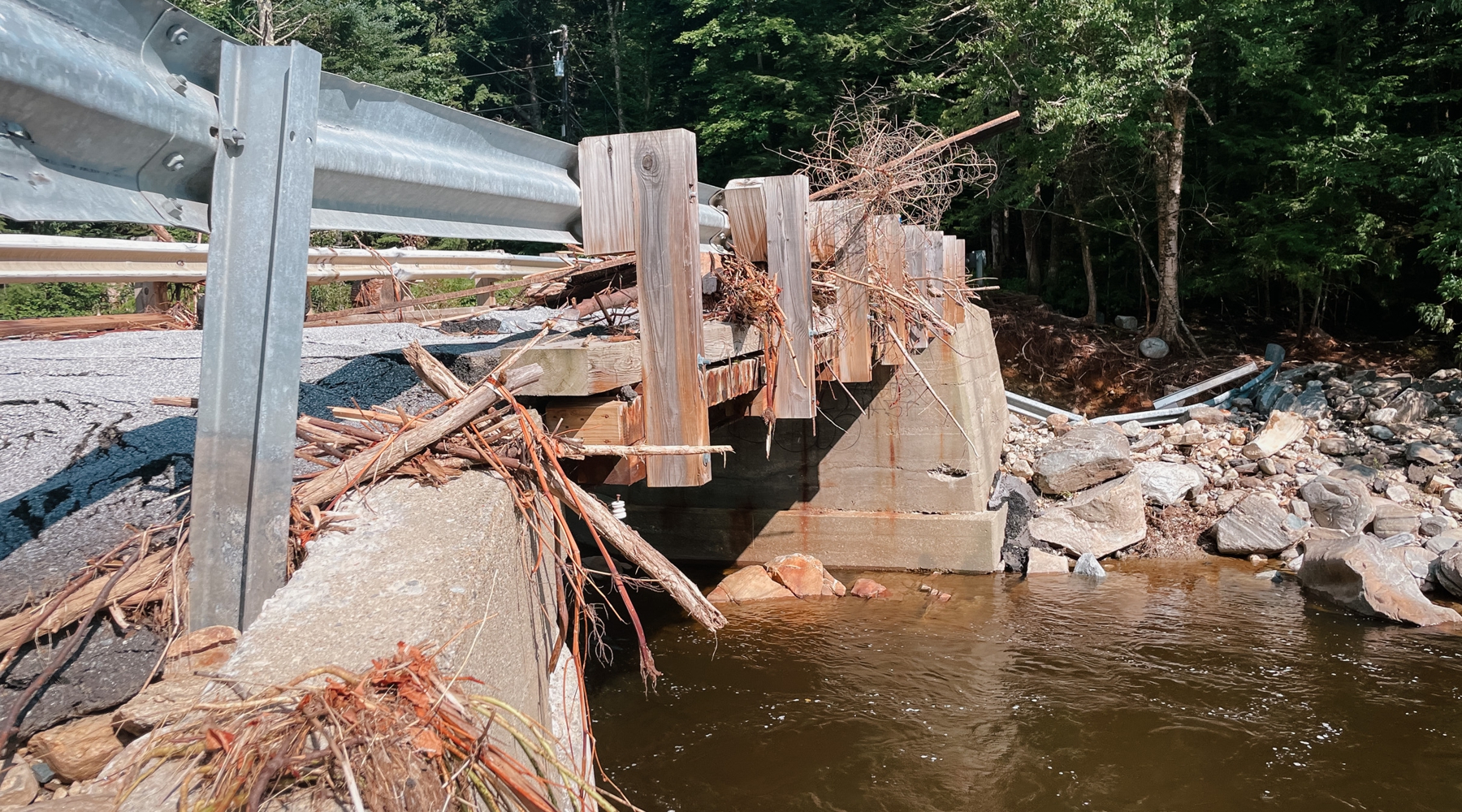 As part of Vermont's July storms, twigs and broken branches are shown on the bridge in between rocks and guardrail. Damage to this bridge was significant.