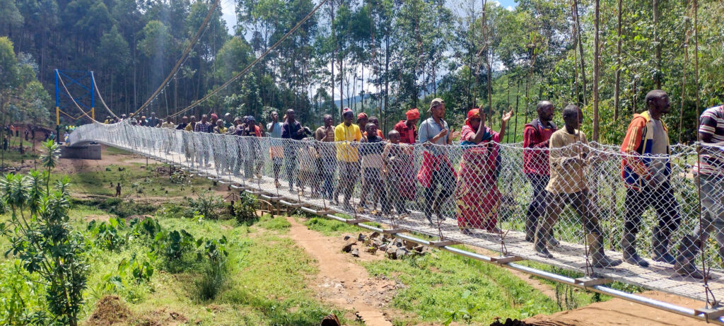 A photo of Rwandans walking on the completed bridge!