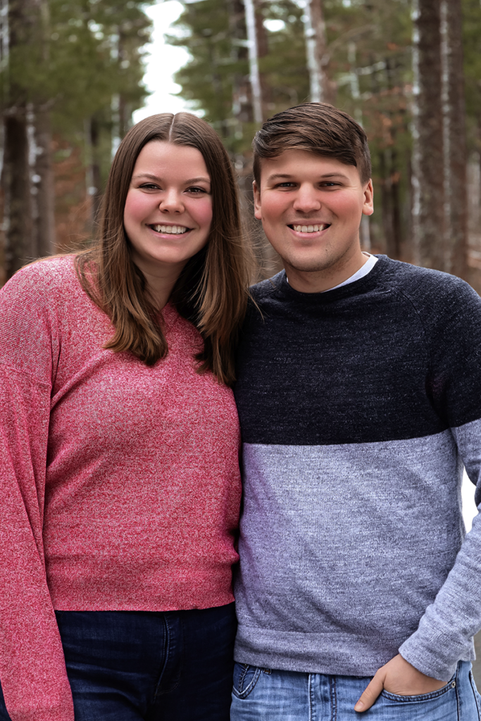 An image of Holly Lauzon with a pink sweater outside standing next to a male. They are smiling.