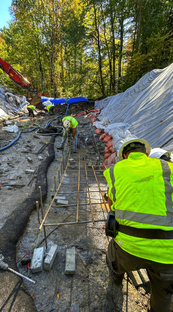 The featured construction image of this post, but in portrait mode. You can see more of the trees surrounding the construction site and it's a sunny day.