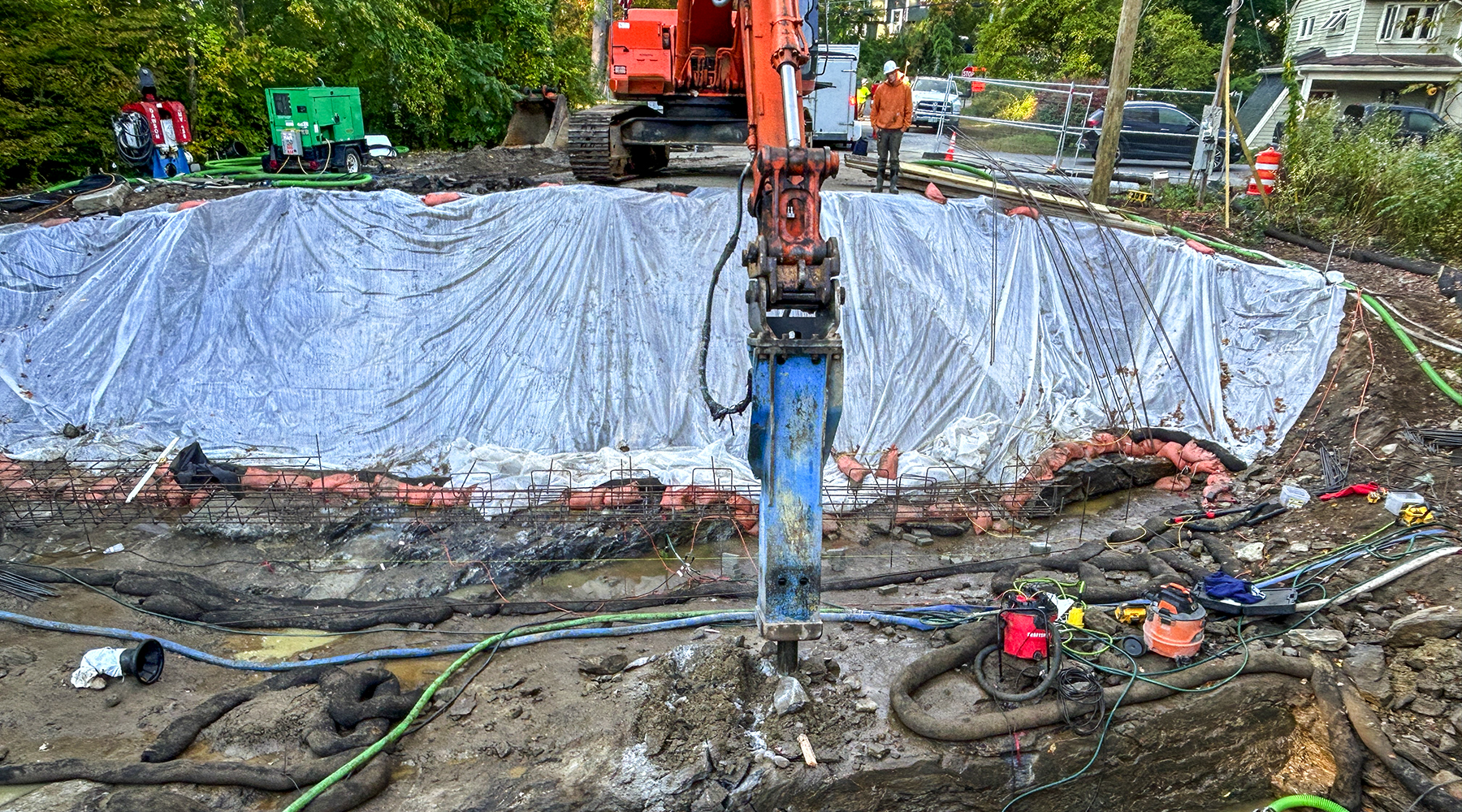 An image of the construction site Andrew has been working at, but this time the camera angle is looking down at the site from one of the slopes. You can see a lot of construction equipment.