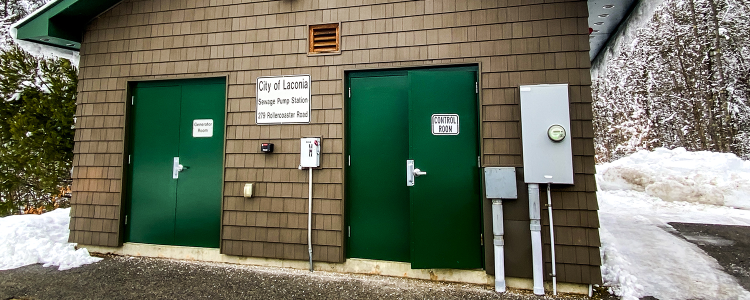 A facility related to our asset management work in Laconia. This building is brown with green doors - a sign out from says Sewage Pump Station. It is a wintery scene.