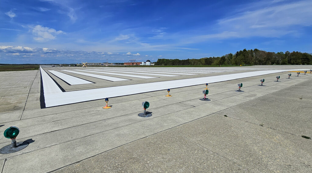 A photo taken at the end of a runway at an airport from the ground.