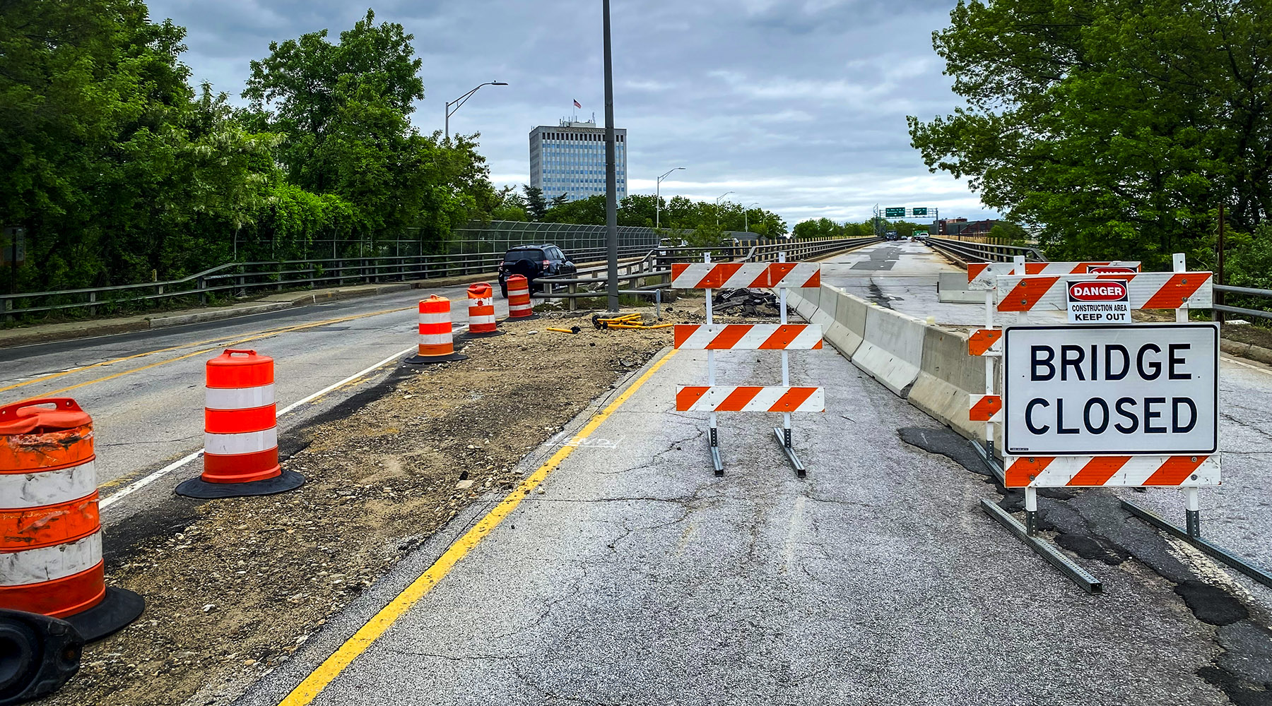 A close up of a closed portion of the road with cones and a Bridge Closed sign.