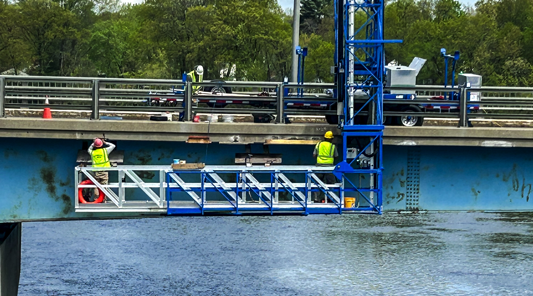 Nashua bridge during construction. The photo is taken from across the bridge in a profile view with workers actively working.