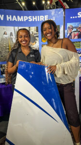 Rebekah is standing next to her sister in the aviation musuem, smiling at the camera and standing near a plane wing.