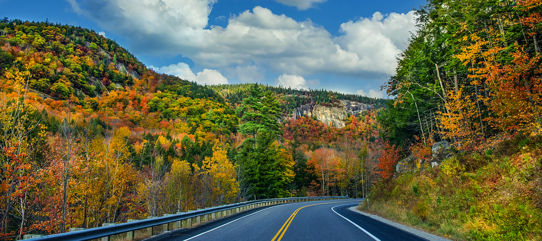 A road in the mountains surrounded by fall foliage.
