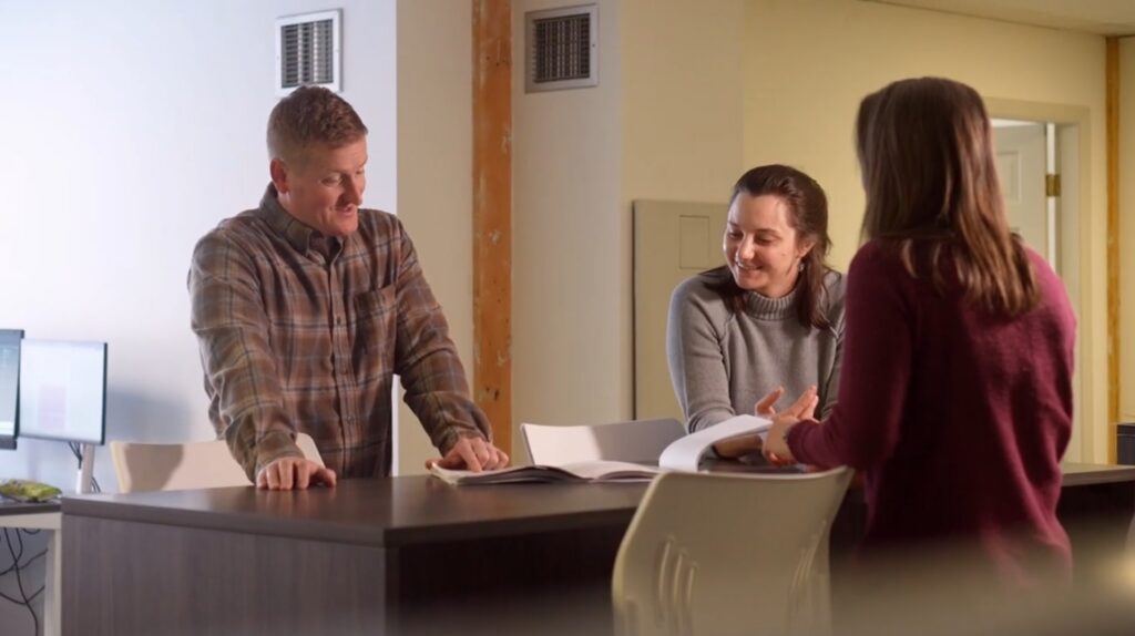 Members of our team in Yarmouth, collaborating around a drawing table.