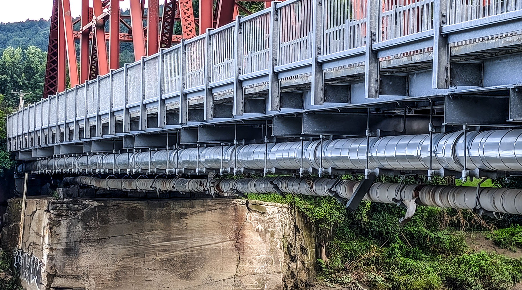 A photo of the bridge profile carrying the utilities of the pump station project.