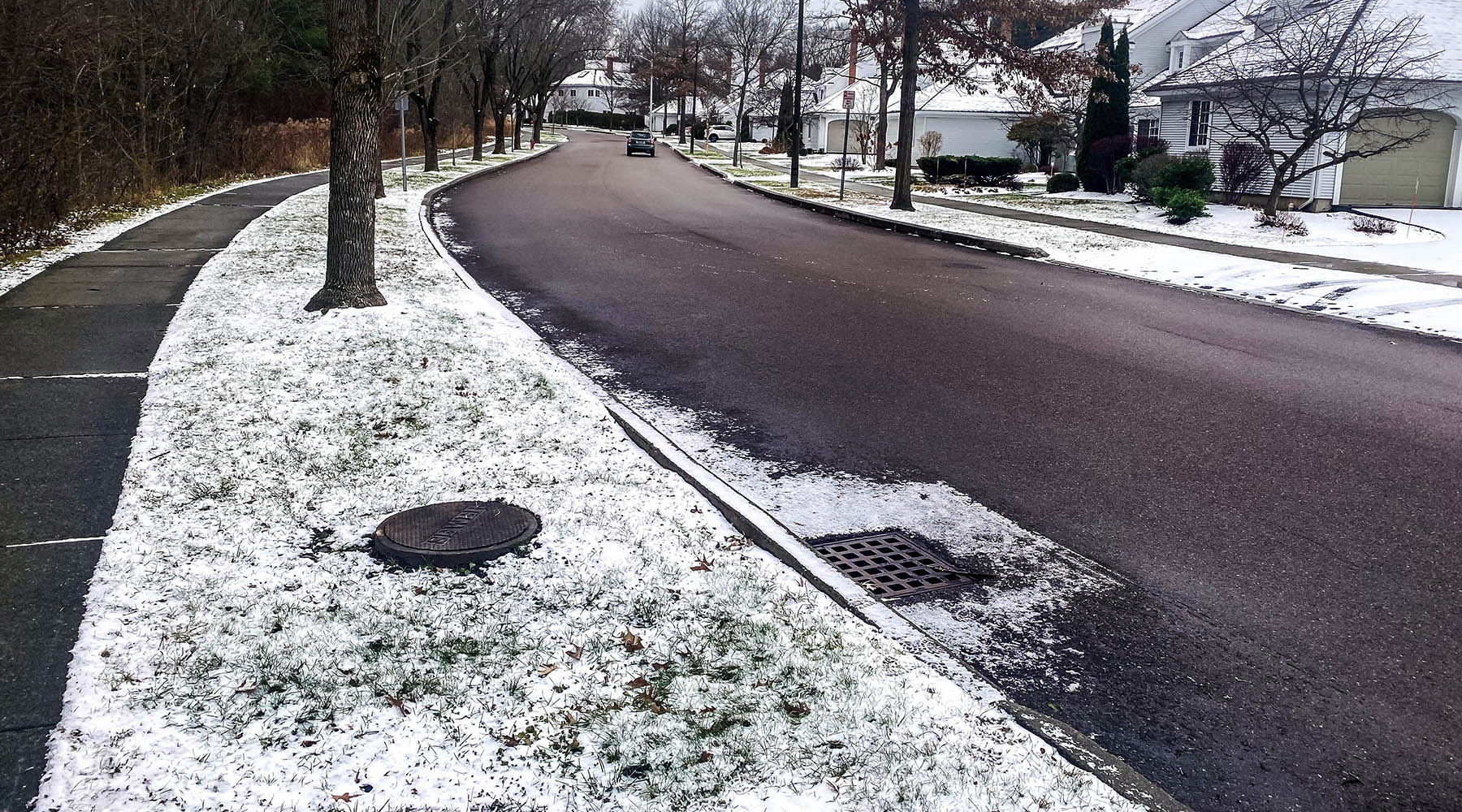 A photo of Oak Beach Drive in winter with storm grates visible.