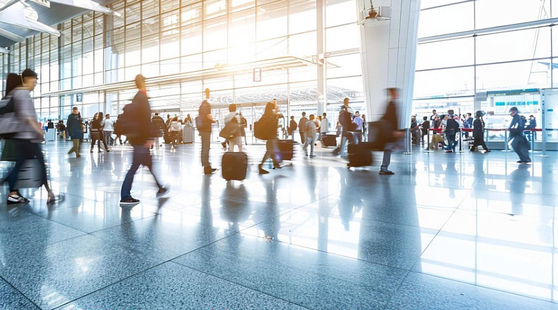 A photo sourced from Pixabay by artist TungArt7. The photo shows passengers moving around in an airport terminal. There is bright light and movement.