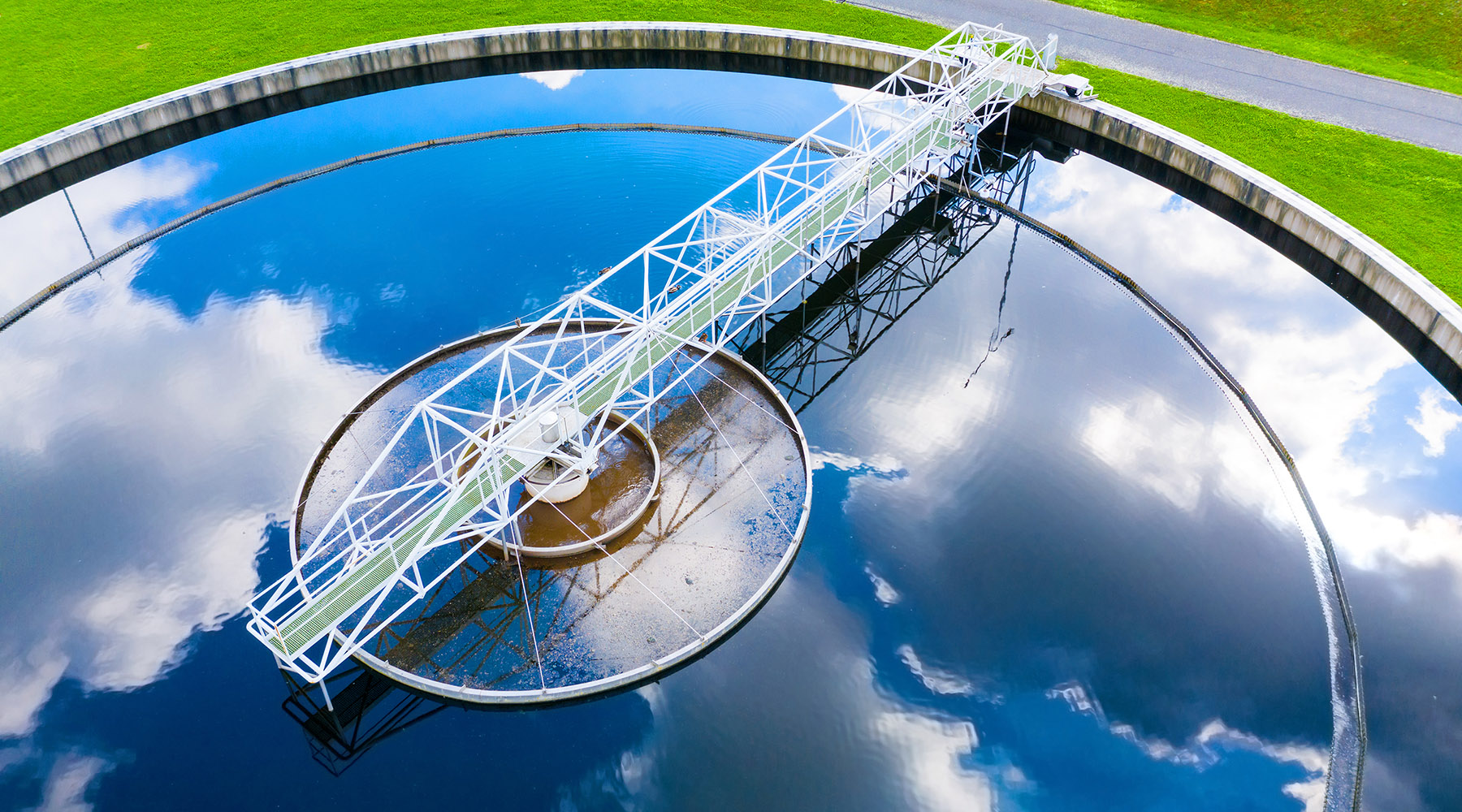 Stock image of a water treatment plant with clouds reflecting in the water